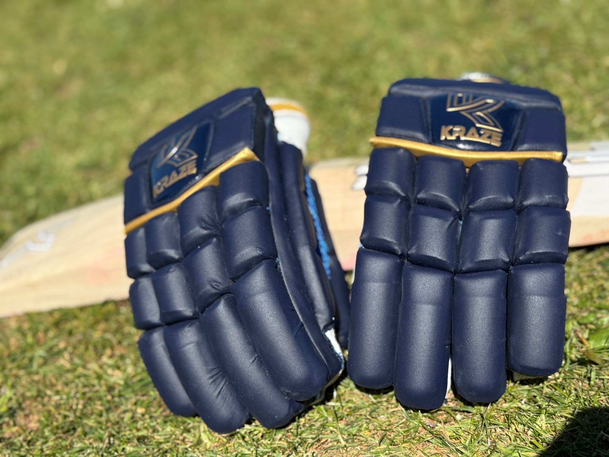 Kraze premium gloves resting on a bat